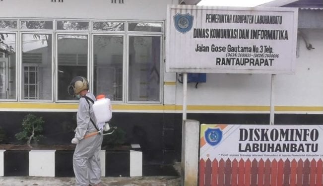 Petugas saat melakukan penyemprotan disinfektan di area Kantor Dinas Kominfo.