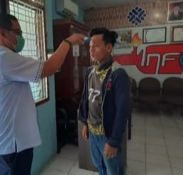 Pegawai Disnaker Asahan memantau suhu tubuh