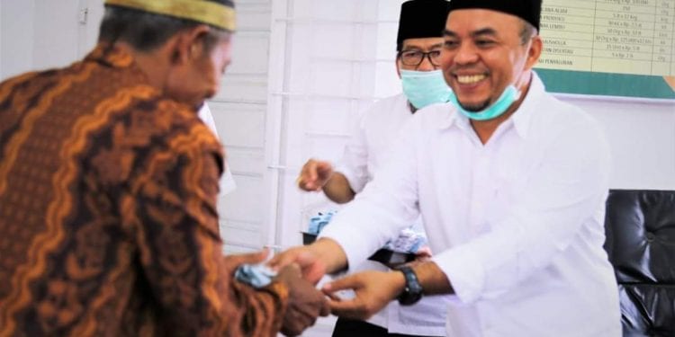 Bupati Labuhanbatu H Andi Suhaimi Dalimunthe ST MT saat menyalurkan bantuan dari Baznas.