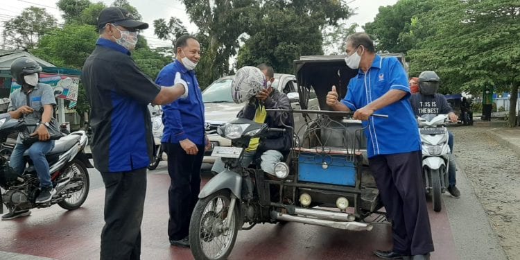 Pengurus Partai NasDem Labuhanbatu saat membagikan masker kepada warga yang melintas.