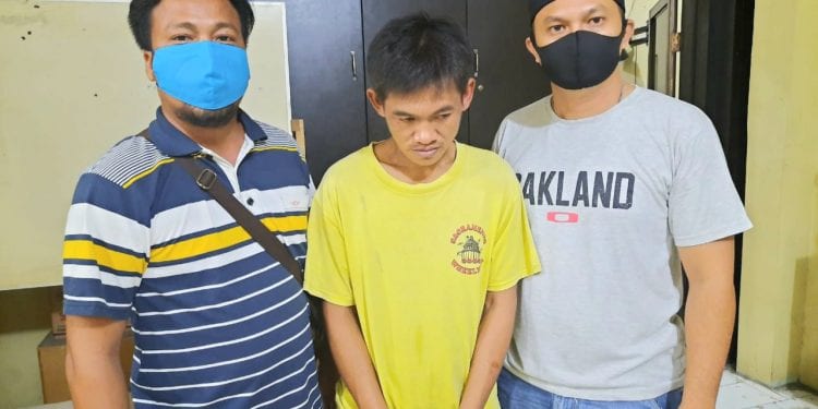 Tersangka Azhari Panjaitan alias Tuah (diapit polisi) saat diamankan di Polres Tanjungbalai.