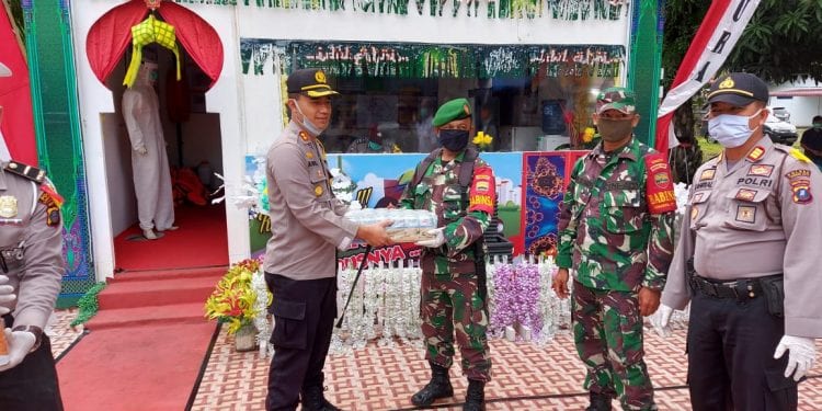 (Ricad Silaban/taslabnews) Kapolres Labuhanbatu AKBP Agus Darojat menyerahkan bingkisan minuman yang diterima Sertu T. Galingging