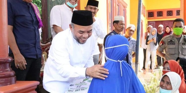 Bupati Labuhanbatu H Andi Suhaimi Dalimunthe ST MT saat memberikan paket sembako kepada salahseorang warga setempat.