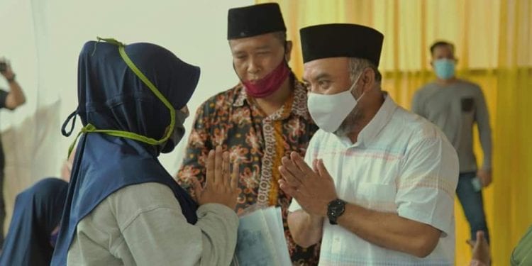 Bupati Labuhanbatu H Andi Suhaimi Dalimunthe ST MT saat menyalurkan bantuan kepada masyarakat.