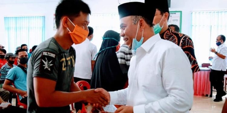 Bupati Labuhanbatu H Andi Suhaimi Dalimunthe ST MT saat menyerahkan BST kepada warga.