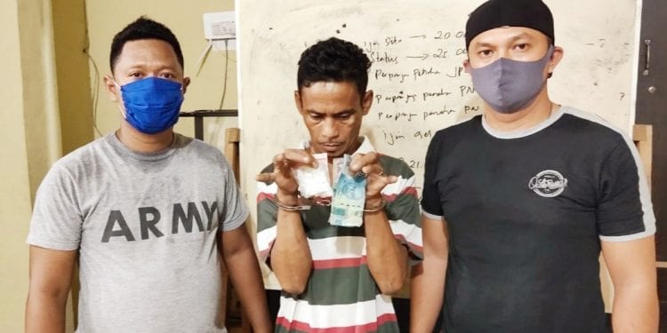 Tersangka Aziddin Batubara dan barang bukti diapit petugas saat diamankan di Polres Tanjungbalai.