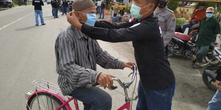 Suasana bagi-bagi masker gratis oleh Sat Res Krim Polres Tanjungbalai.