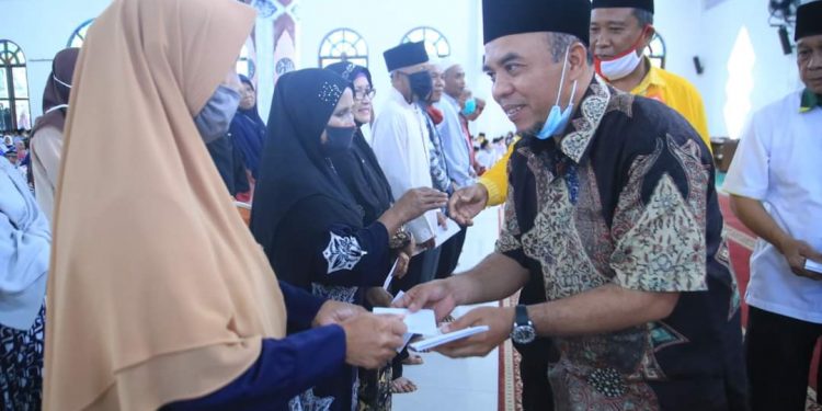 Bupati Labuhanbatu, H Andi Suhaimi (kanan) saat menyampaikan bantuan sembako kepada warga.