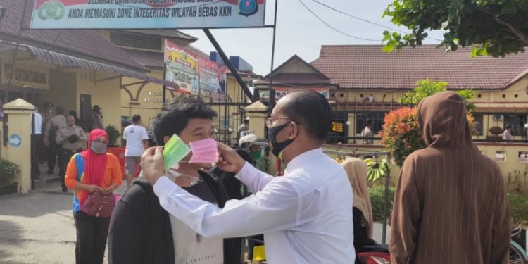 Suasana saat personil Sat Reskrim Polres Tanjungbalai membagi-bagikan masker secara gratis.
foto/teks: ignatius siagian