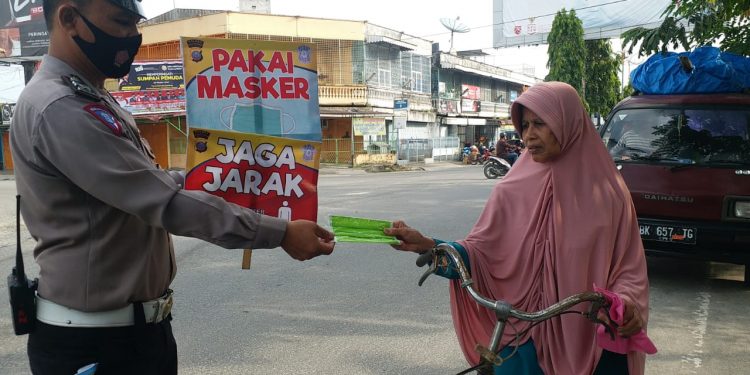 Suasana Operasi Zebra Toba 2020 yang diisi dengan pembagian masker gratis dan penempelan stiker.