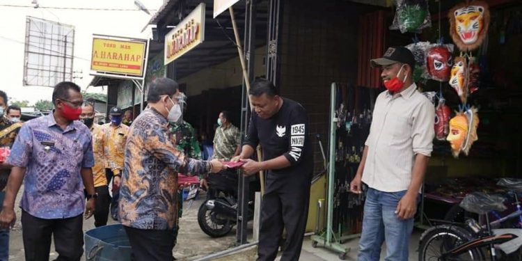 Pjs Bupati Labuhanbatu saat memberikan masker kepada warga.