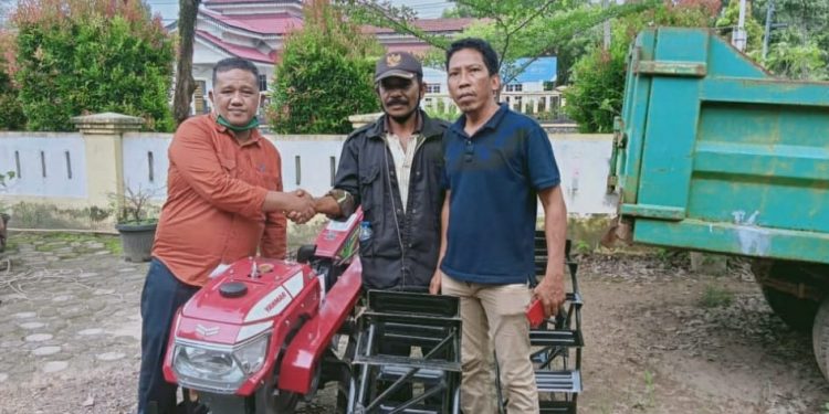 Ketua koptan di Sei Penggantungan (tengah) saat menerima bantuan traktor.