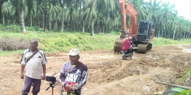 Kades Padang Pulau dan Humas PT DPI saat mengawasi perawatan sementara jalan Desa Padang Pulau.