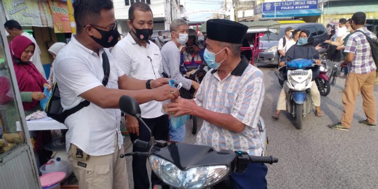 Kanit Reskrim Polsek Kota Kisaran, Iptu Marzuki SH membagikan takjil kepada warga yang melintas.