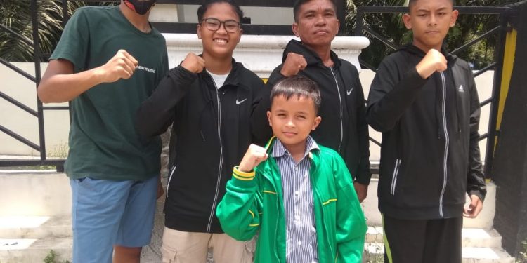 Atlit tinju didampingi pelatih dan tim manajer.