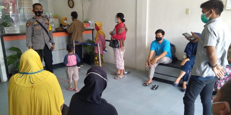 Personil Polsek Pulau Raja mengawasi warga penerima program BPUM di BRI Rahuning.
foto/teks: sofyan butar butar