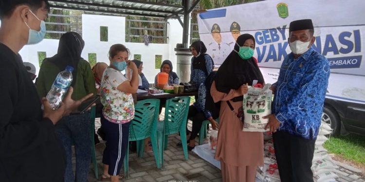 Kepala Bidang Guru dan Tenaga Kependidikan (GTK) Kabupaten Labura, Irwan SPd MPd menyerahkan sembako kepada warga usai divaksinasi.
foto/teks: richard silaban