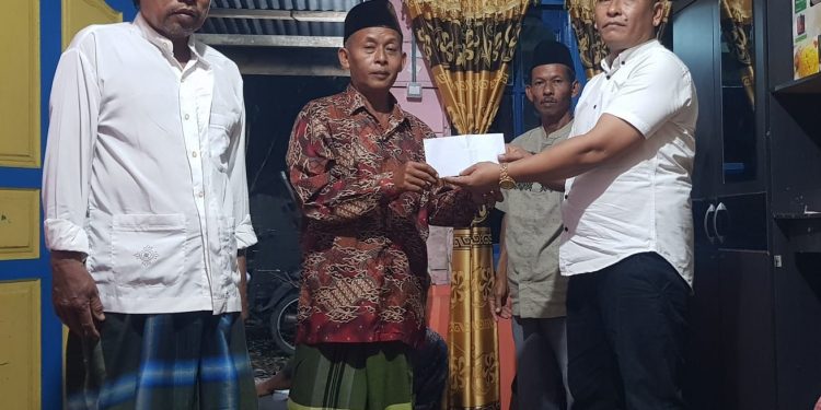 Ketua MOI Labuhanbatu Syaiful Bahri Ritonga (baju putih) saat memberikan bantuan kepada Perwiritan Al-Ikhlas.