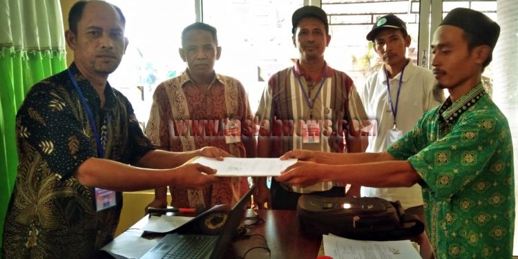 foto/teks: edi surya
Warsito (batik hijau) menyerahkan berkas pendaftaran untuk menjadi balon kades Meranti kepada Panitia Pilkades.