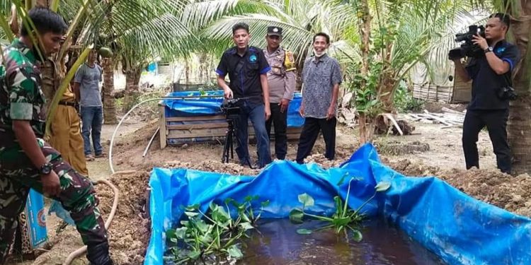 Sejumlah pegawai Dinas Kominfo Labuhanbatu saat berada di salahsatu desa mengambil gambar yang akan di publikasikan.