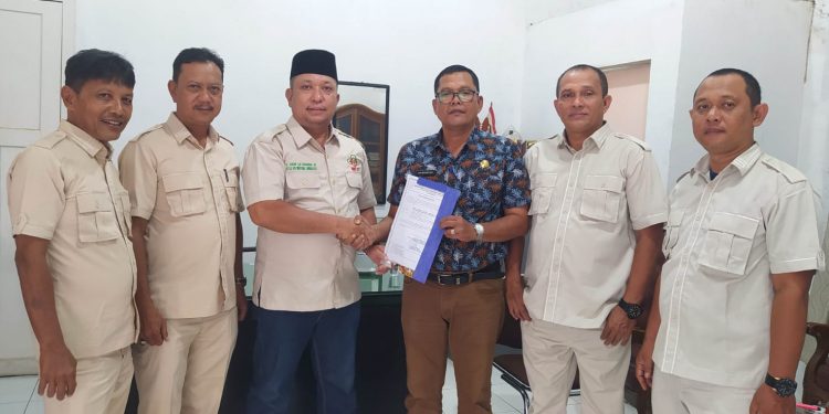 Kepala Badan Kesbangpol Labuhanbatu H Nilwansyah, SH saat menyerahkan surat terdaftar administrasi kepada pengurus DPC HKTI Labuhanbatu. 