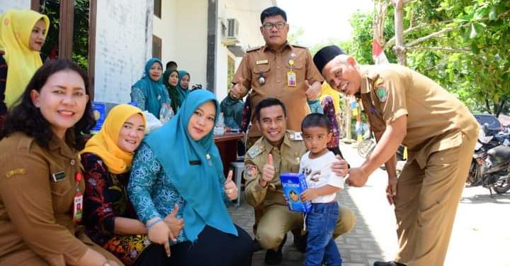 Wakil Bupati Labura H. Samsul Tanjung didampingi Kepala Puskesmas Sukarame dr. Elida Silaban memberikan susu kepada balita sebagai upaya pencegahan stunting.