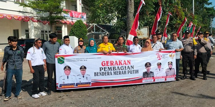 Forkopimcam bersama Kapolsek NA IX-X saat melakukan kegiatan bagi bendera merah putih.