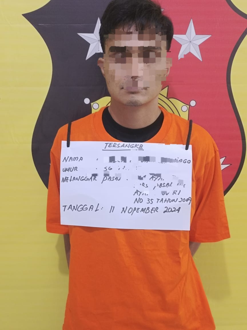 Salah seorang tersangka saat di kantor polisi.