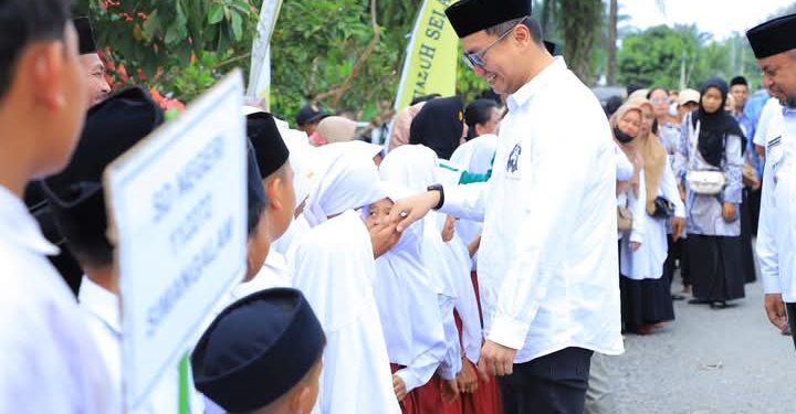 Bupati Labura, Dr. Hendri Yanto Sitorus, disambut siswa saat menghadiri MTQ Ke-XI dan FSQ Ke-X di Desa Simangalam, Rabu (12/2/2025)